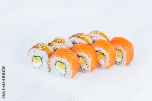 Japanese Sushi Roll with avocado, Philadelphia cream cheese with salmon and eel on top. isolated on gray background. Served with Unagi sauce and sesame seeds seeds. Asian dish Menu isolation.
