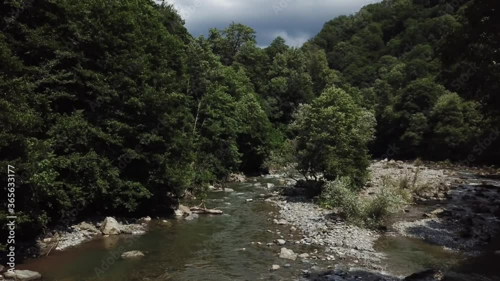 4K aerial point of view. Low altitude flight over fresh fast mountain river with rocks at sunny summer morning. Green pine trees and sun rays. Raw colors, no color correction. 4K aerial point of view. Low altitude flight over fresh fast mountain river with rocks at sunny summer morning. Green pine trees and sun rays. Raw colors, no color correction.