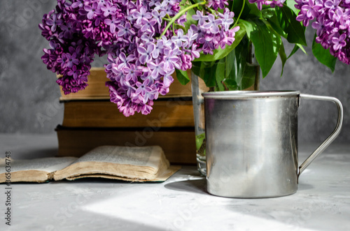 bouquet of lilacs on the table with books