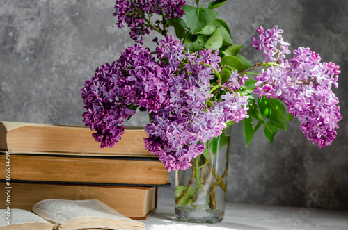 bouquet of lilacs on the table with books