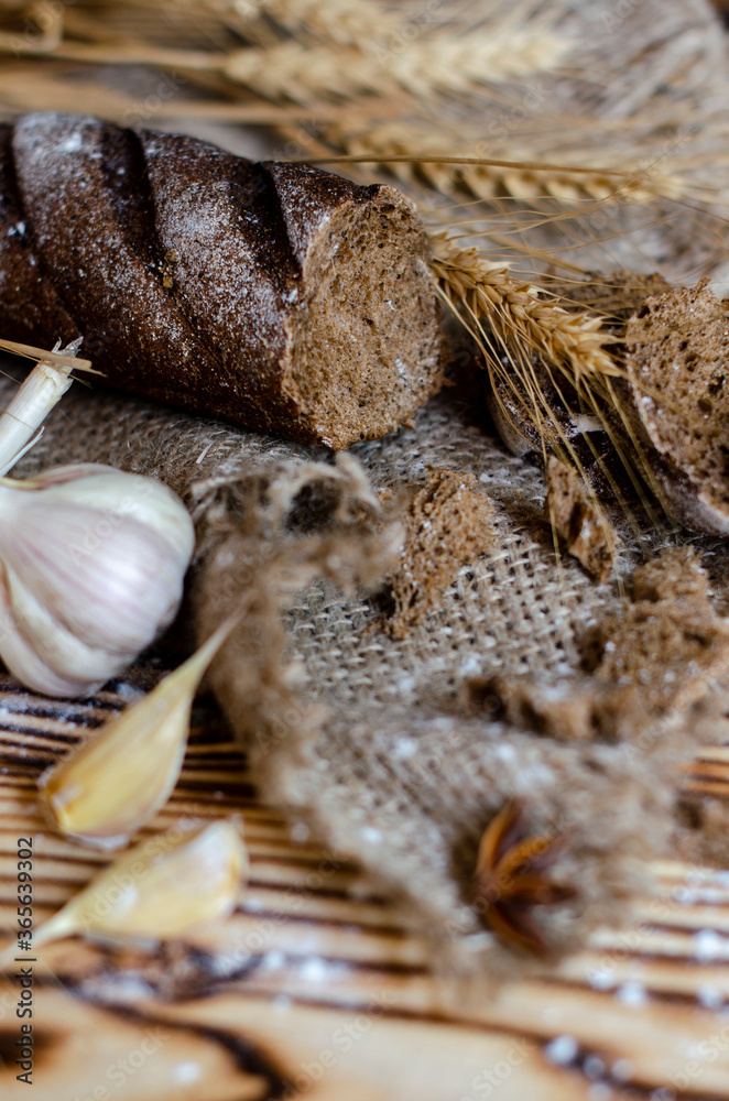 black bread on a wooden background with wheat ears black bread on a wooden background with wheat ears