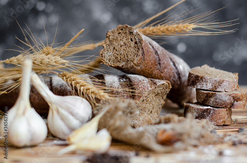 black bread on a wooden background with wheat ears