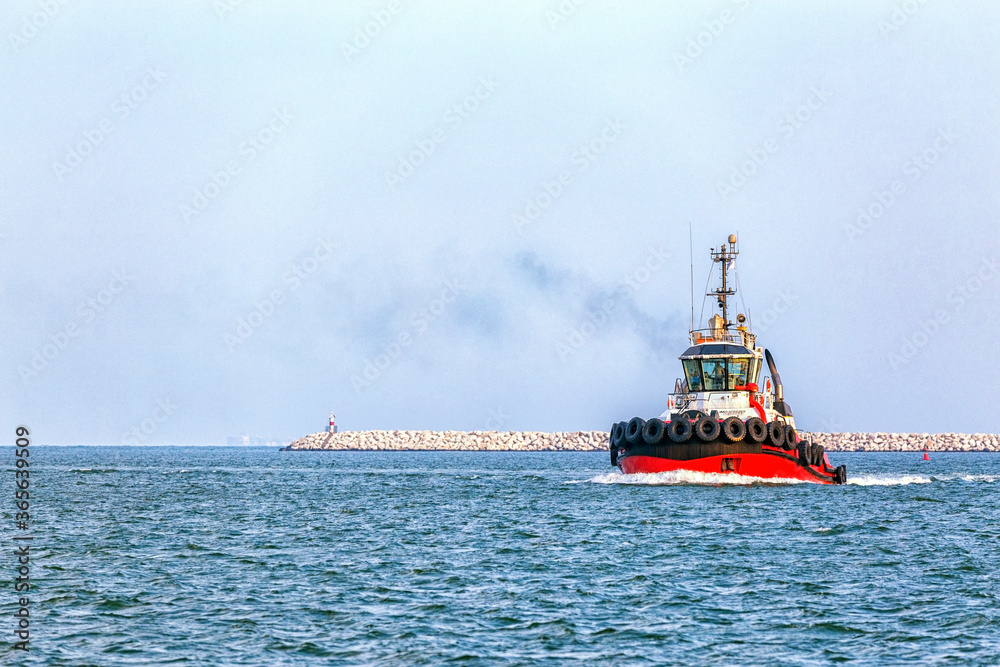 Fototapeta premium MERSIN, TURKEY - AUGUST 01, 2018: View of the tugboat or towboat of Mersin International Port. A tug (tugboat or towboat) is a type of vessel that maneuvers other vessels by pushing.