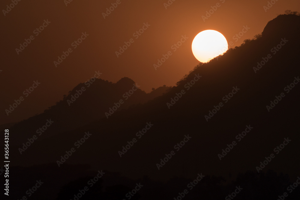Magical close up shot of Sun setting down behind mountains