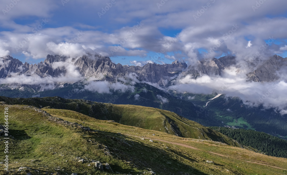 Scattered clouds above and below the Sesto Dolomites massif in Italy as seen from the Carnic Peace Trail along the Carnic Alps on the way up the Hornisch Eck summit, Carnic Highroute trek, Austria.