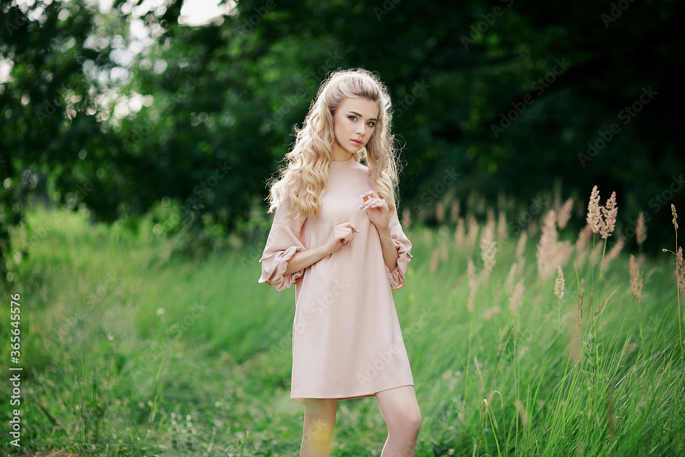 Beautiful carefree woman in dress in green fields being happy outdoors and enjoying spending time with nature. Spring and summertime. Beautiful carefree woman in dress in green fields being happy outdoors and enjoying spending time with nature. Spring and summertime.