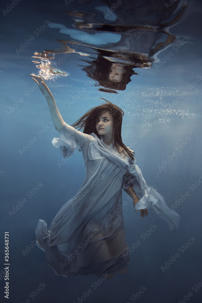   Portrait of a girl in a blue dress under water      