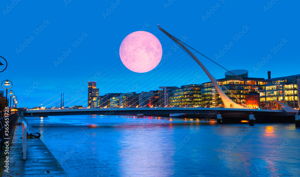 Samuel Backett Bridge (Harp Bridge) at twilight blue hour with full moon - River Liffey, Dublin  Ireland 