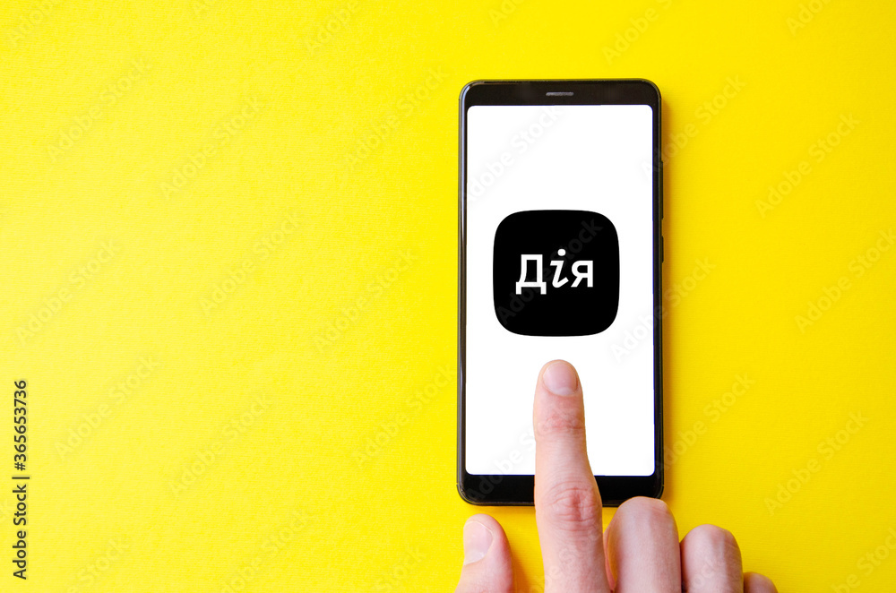 A male hand holds a smartphone, points a finger, types. Communication on a smartphone, correspondence. Place for text. Smartphone in hand on a yellow background. A male hand holds a smartphone, points a finger, types. Communication on a smartphone, correspondence. Place for text. Smartphone in hand on a yellow background.