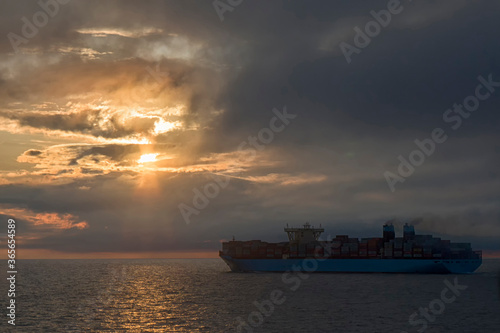 large container ship on the background of sunset side view