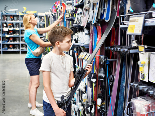 Boy with alpine skis in sport store