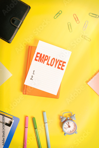 Conceptual hand writing showing Employee. Concept meaning an individual working for wages in particular at the nonexecutive level Pile of empty papers with copy space on the table photo