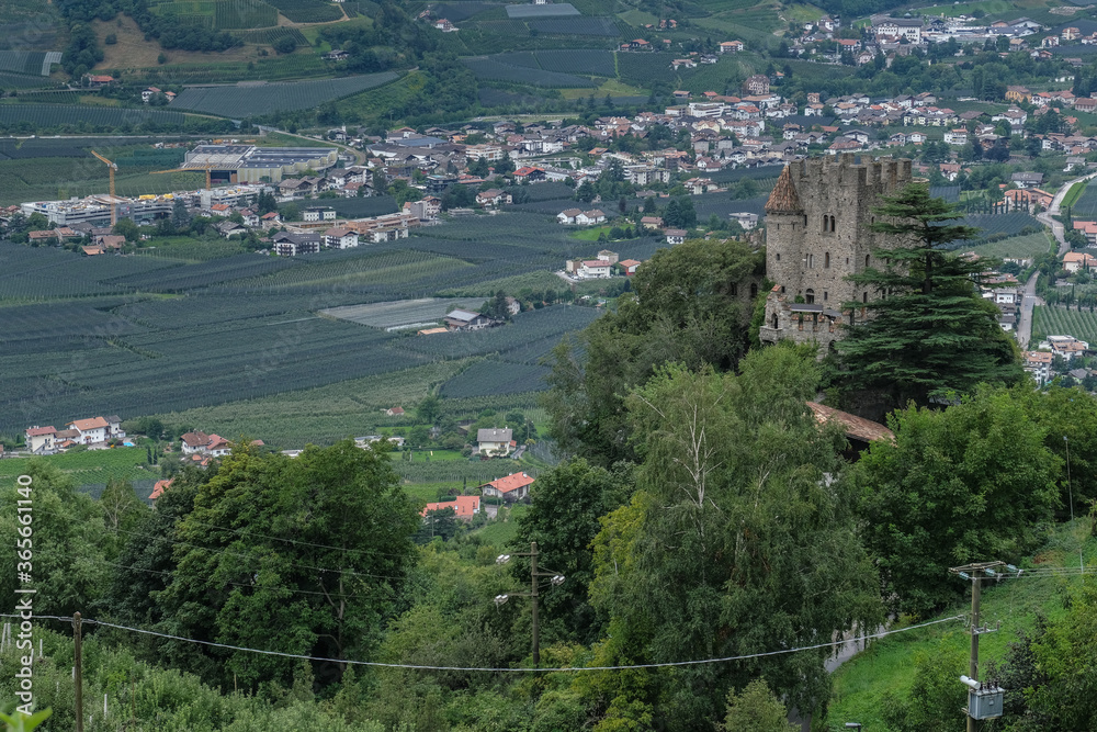 View of Fontana medieval castle above Merano as seen from the Apple Orchards trail above the town, Merano, South Tyrol, Italy. View of Fontana medieval castle above Merano as seen from the Apple Orchards trail above the town, Merano, South Tyrol, Italy.