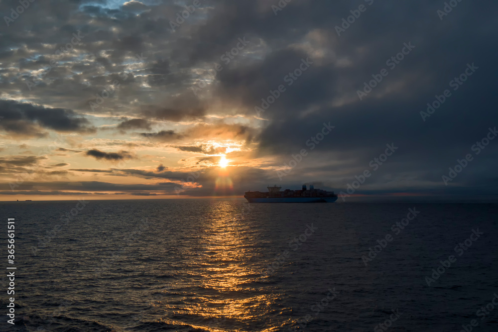 large container ship on the background of sunset side view