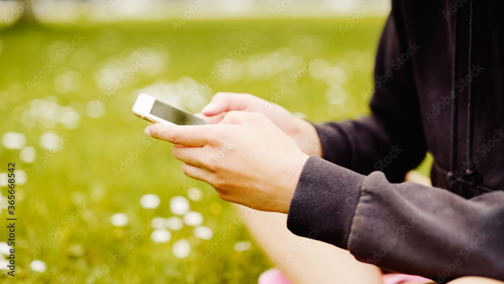 Close up of female hands using a smart phone in a city park. Close up of female hands using a smart phone in a city park.