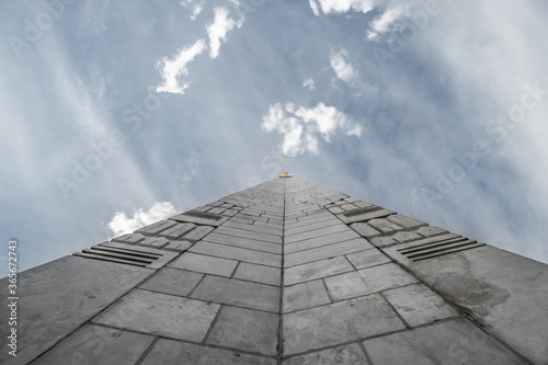 Bottom view of a tall old marble obelisk facing the sky