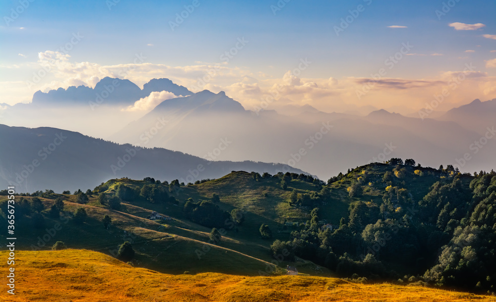Sunset on countryside and mountains at the top of mount Pizzoc (Treviso province, veneto, Italy) against blue sky and clouds