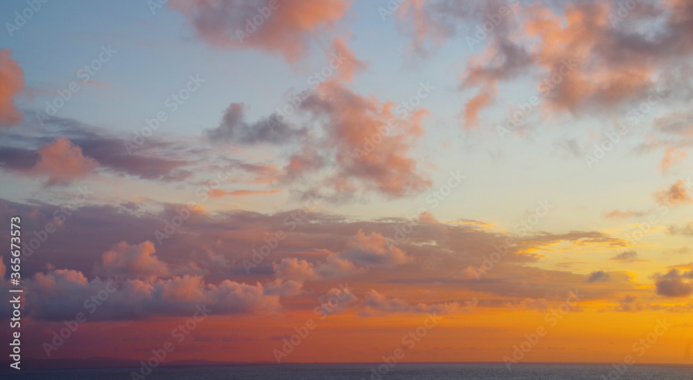 sunset over the sea with clouds low on horizon