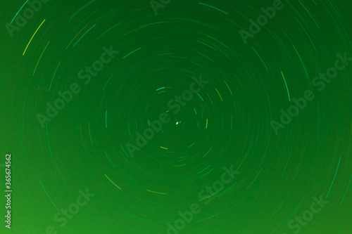 Background of round or circular star track or trajectory on the green clear night sky. Symbol of space  cosmos  expanse infinity and universe