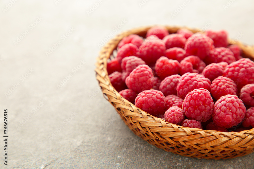 Fresh raspberry in a basket on grey concrete background with copy space Fresh raspberry in a basket on grey concrete background with copy space