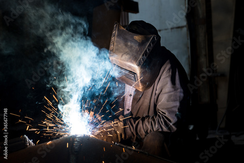 Closeup worker in a mask doing the welding in a workshop
