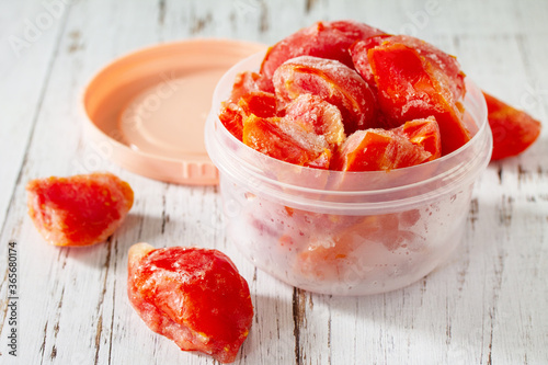 Healthy food is frozen food for the winter. Containers with frozen tomatoes. photo