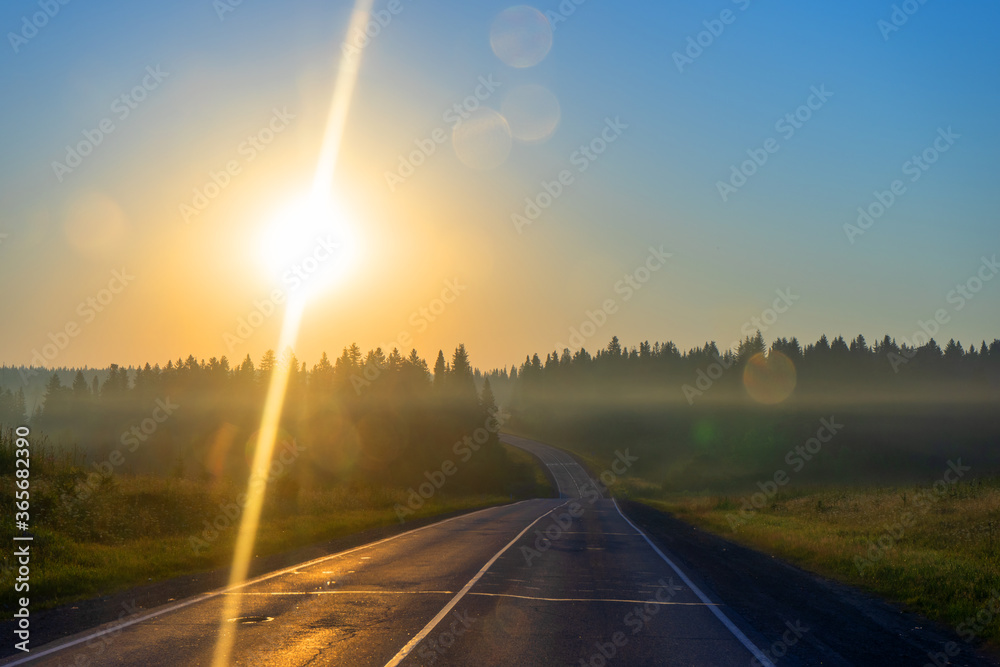 early morning on the road, around the forest, fields and sunrise