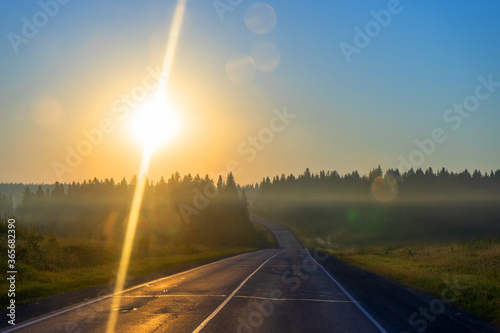 early morning on the road, around the forest, fields and sunrise