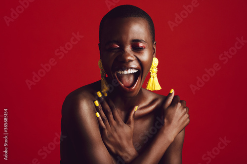 Cheerful fashion model with colorful makeup in studio