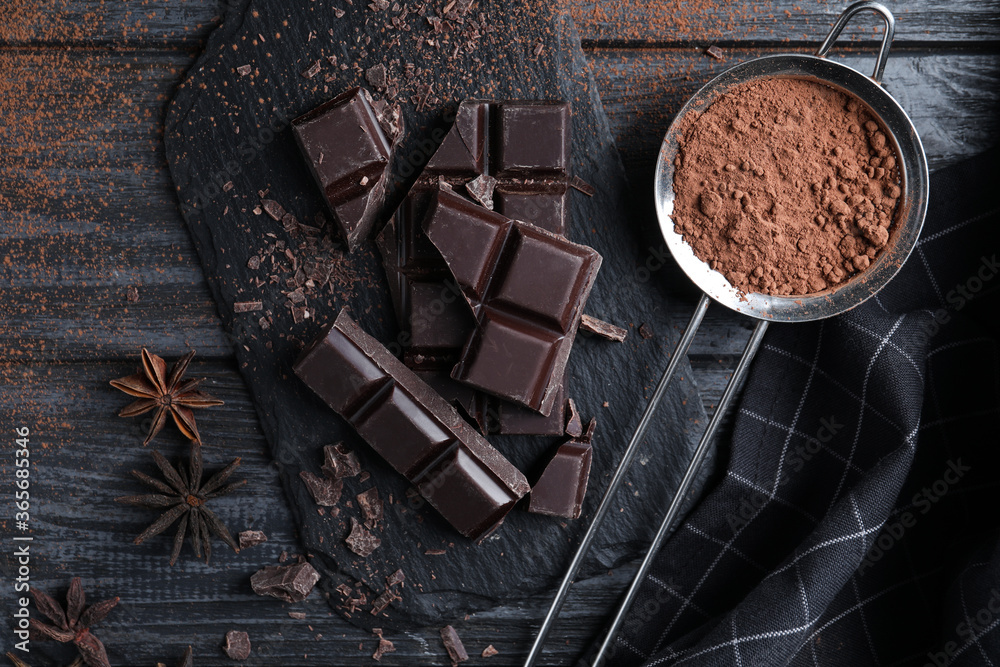 Flat lay composition with delicious dark chocolate on black wooden table Flat lay composition with delicious dark chocolate on black wooden table