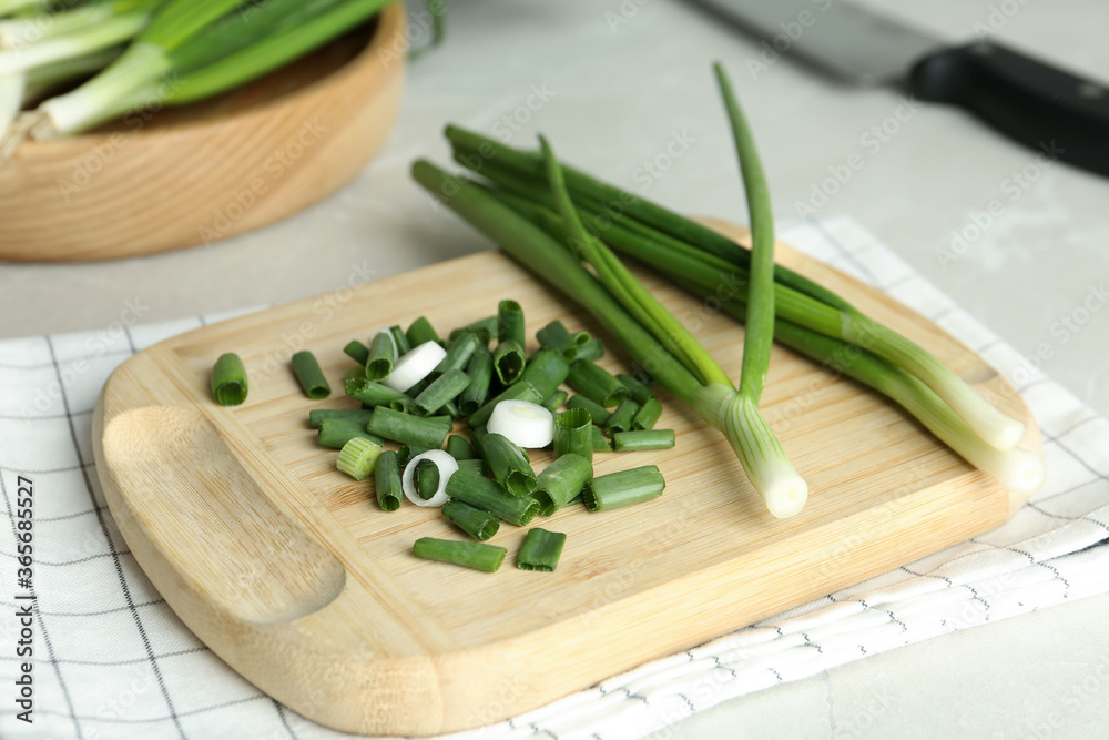 Fresh green spring onions on wooden board