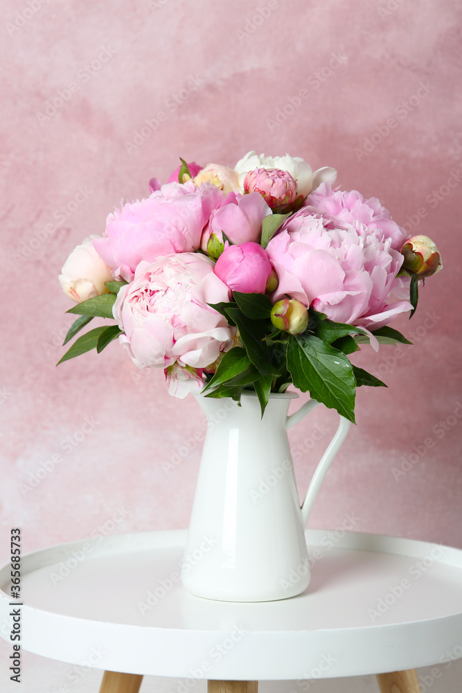 Bouquet of beautiful peonies in vase on white table