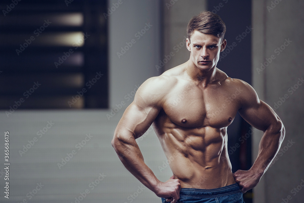 Bodybuilder strong man pumping up abs muscles Bodybuilder strong man pumping up abs muscles