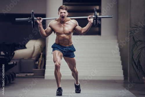 bodybuilder fitness man pumping up legs muscles.