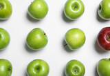 Red apple among green ones on white background, top view