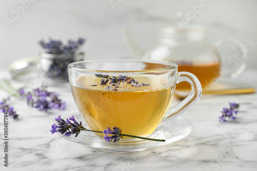 Fresh delicious tea with lavender and beautiful flowers on white marble table