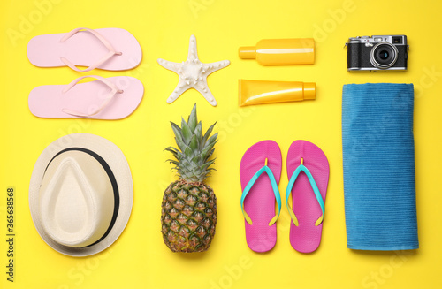 Beach accessories on yellow background, flat lay