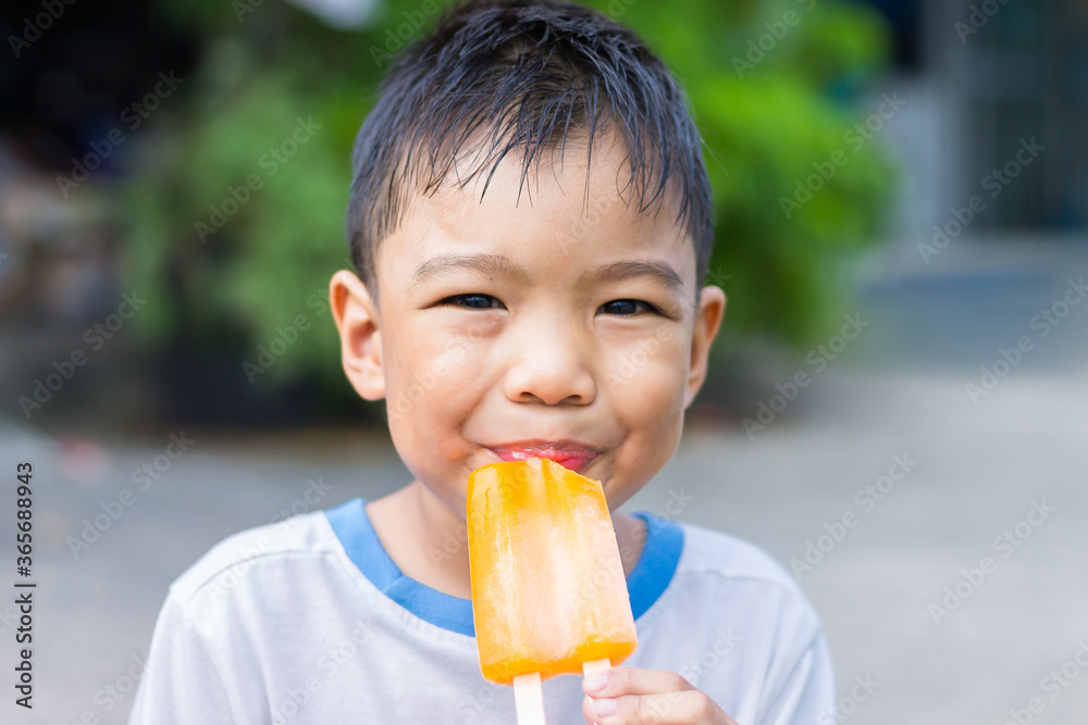Selective focus. Happy Asian child boy eating an pink vanilla ice cream. Summer season, Delicious feeling, childhood sloppy face. Selective focus. Happy Asian child boy eating an pink vanilla ice cream. Summer season, Delicious feeling, childhood sloppy face.