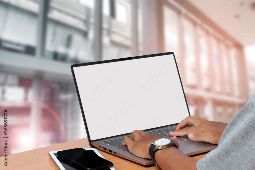 young man using laptop with a blank screen in interior building. young man using laptop with a blank screen in interior building.