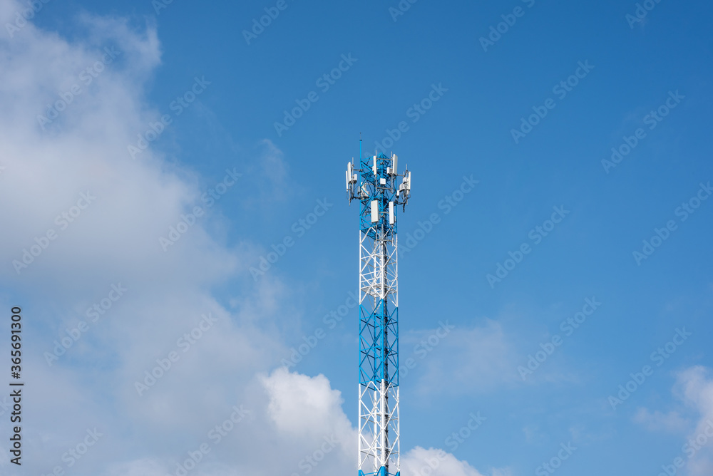 Wireless communication antenna transmitter. Telecommunication tower with blue sky.