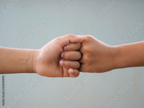 Boy fist bumping On a gray background.It is a new greeting during t