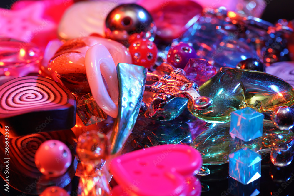 Colorful glass beads on mirrored surface photographed in studio