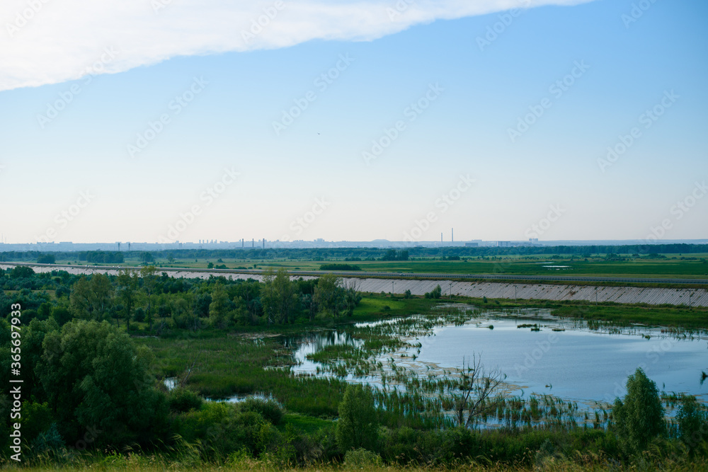 blue lake with a passing highway and a view of the city. landscape