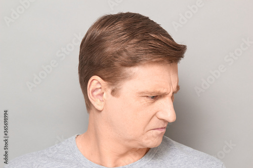 Portrait of angry disgruntled mature man with frowning face