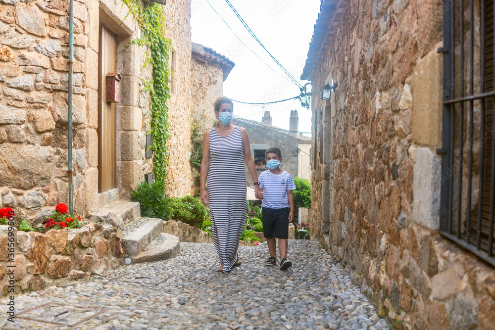 Mother and son walking on a tourist village on holidays.