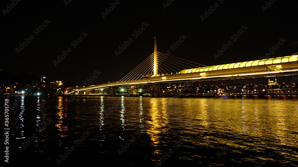 Obraz premium Golden Horn Metro Bridge in Istanbul at night, black sky and sea, Gold color reflection, background