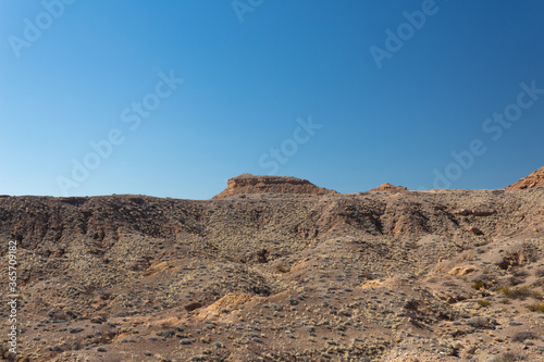 View across a wide valley in the New Mexico desert, vast open canyon with sage brush with blue sky, horizontal aspect