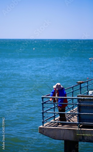 man sitting and fishing on the pier © J.C.Aires