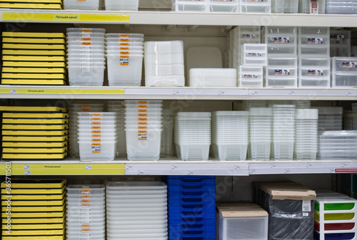 Stacked of transparent, white, blue and yellow plastic boxes for storage. Inside the warehouse in store