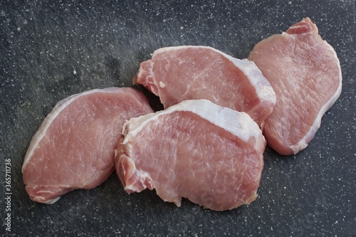 raw pork chops on a cutting board